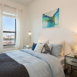 bedroom with nightstands and a large window